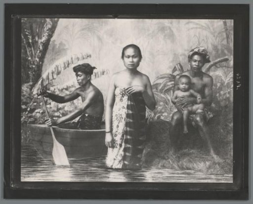 Studio photograph of an unknown Indonesian woman and two men, with a child