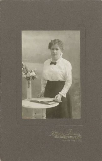 Studio portrait of a woman with a book at a table