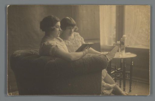 Portrait of Henny and Cato Merks reading on a bench