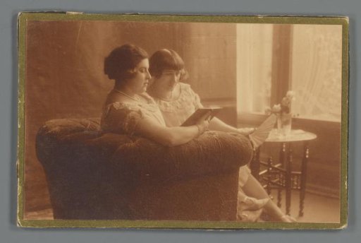 Portrait of Henny and Cato Merks reading on a bench