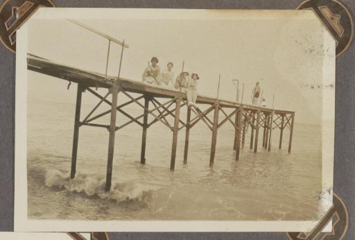 Group sitting on a pier at a beach, probably in southern France