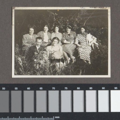 Group portrait of six women, a man and a dog in the shrubbery at Schoorl