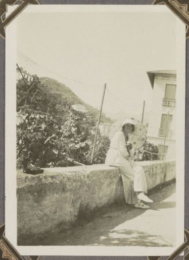 Woman sitting on a wall along a road in southern France