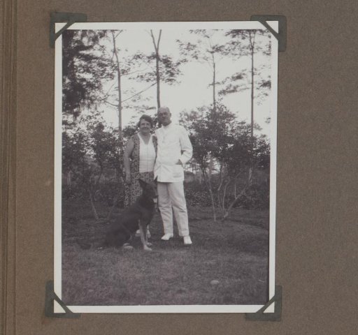 Man and woman with a shepherd dog in a garden