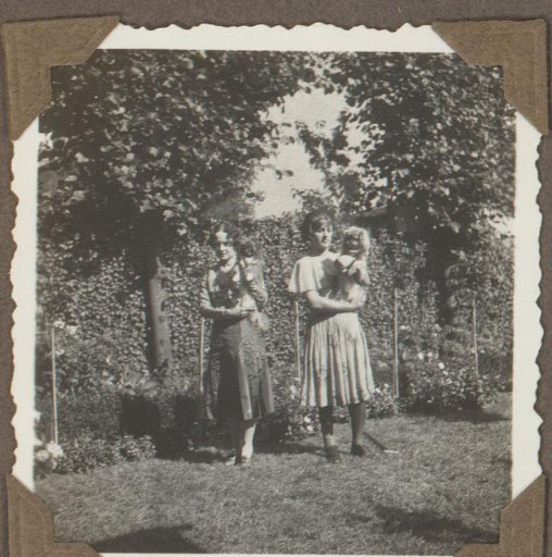Henriëtte Wassink and an unknown person with dogs in a garden