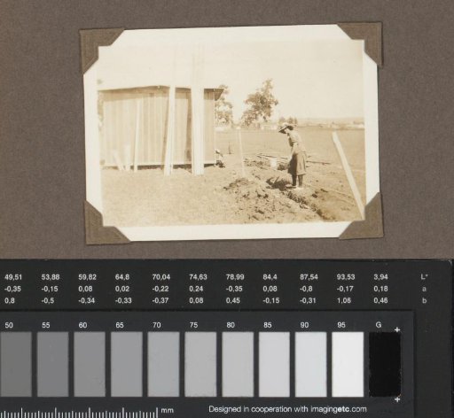 Woman digging near a barn