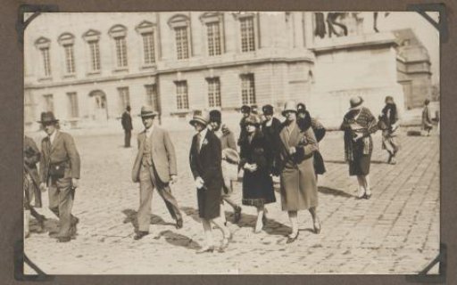 Group of people walking before a palace, with Dootje van Zijll de Jong and Henriëtte Wassink in the center
