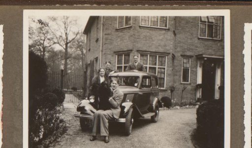 Group portrait of a company by a car