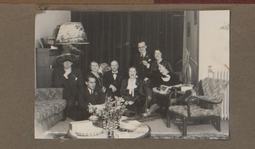 Group portrait of a company at a party in a living room