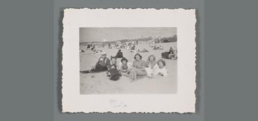 Group portrait of two unknown men and four women on the beach