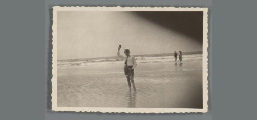 Boy waving in the surf
