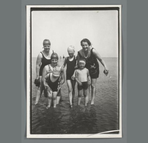 Group portrait of unknown women with children standing in the sea