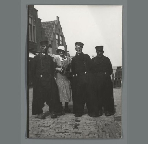 Group portrait of an unknown woman and three unknown men in Volendam costume