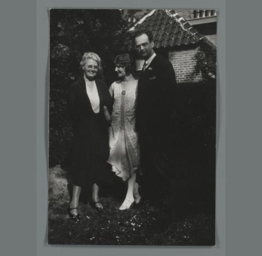 Group portrait of three unknown persons in a garden