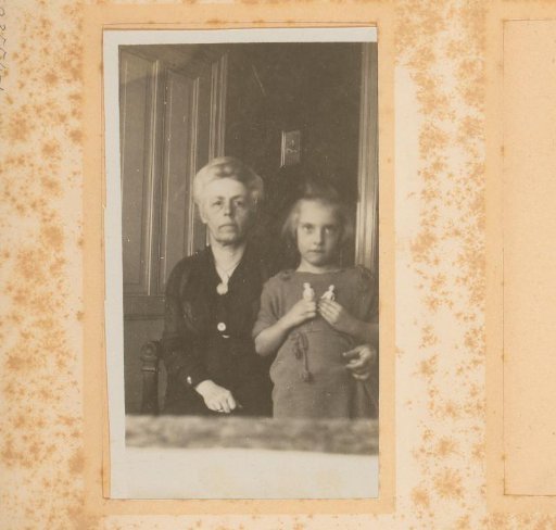 Double portrait of an old woman and a girl with dolls