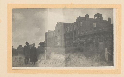 Married couple standing before a building in a dune landscape