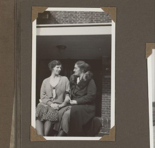 Two Women Sitting on a Wall, Arm in Arm