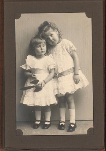 Portrait of Two Girls Standing Against a Wall