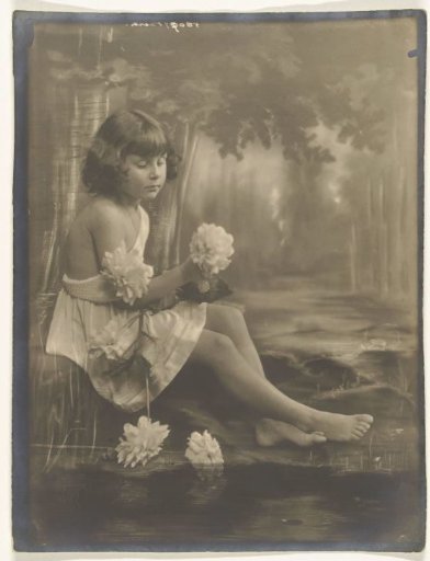 Portret van meisje op blote voeten met bos bloemen in de hand