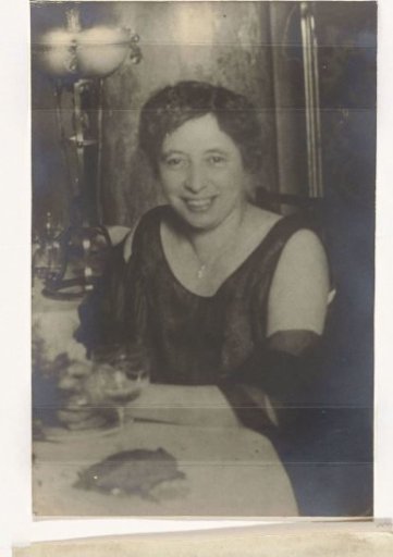 Portret van een oudere vrouw aan tafel in gala jurk