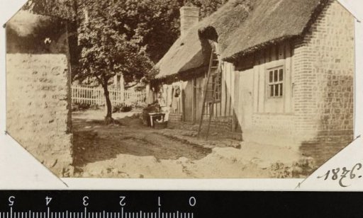 View of a house with a ladder against the thatched roof