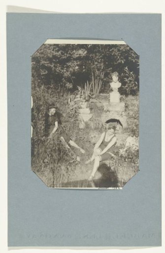 Two women in a garden by a pond
