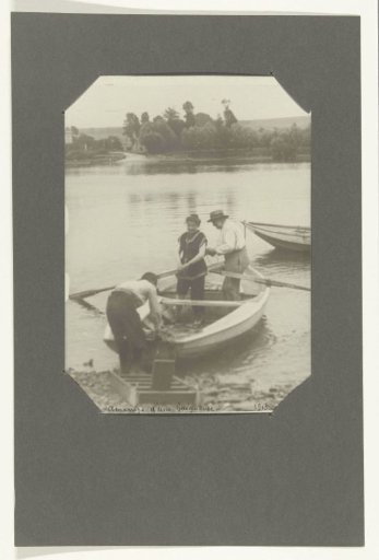 Three people by a rowing boat