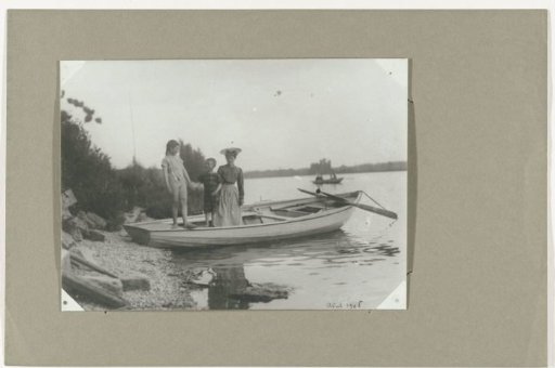 Group portrait of an unknown woman and two children in a rowing boat