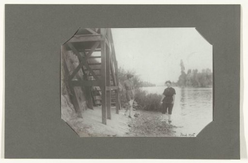 Two women in bathing costume by a staircase on a bank