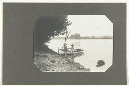 Two persons by a sailboat on a bank