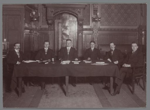 Portrait of six men behind a table
