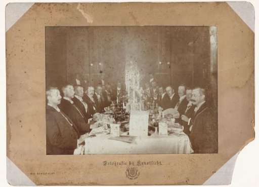 Group portrait of men in suits during a dinner
