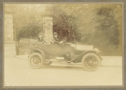 Man and woman in a car near a gate