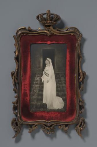 Portrait of Queen Wilhelmina in a white dress, standing on a staircase