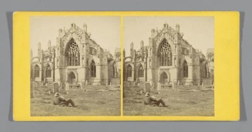 Ruin of Melrose Abbey with a man lying in the grass