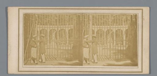 Two men before a fence in the Gardens of Versailles