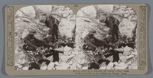 Giving water to a wounded pal beside a Hun blockhouse shattered in our advance at Hooge, Ypres