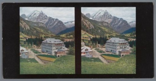 View of a mountain landscape at Canazei, with a building in the foreground