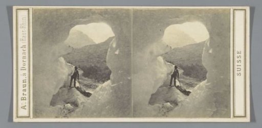 Man at the entrance of a cave in the Upper Grindelwald Glacier in the Bernese Alps, Switzerland