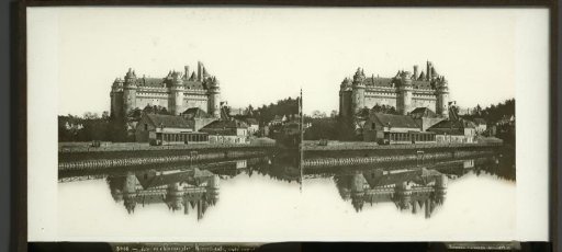 View of the Château of Pierrefonds, France, with a lake in the foreground