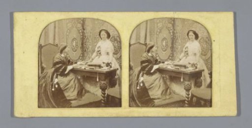 Two women at a desk, one woman wearing a wedding dress and bouquet