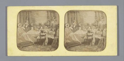Family around a dining table, father reading the Bible