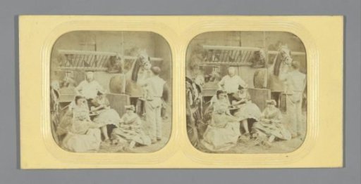 Four women, two men and a horse in a stable