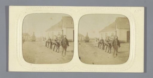 Seven men on a railway track, a steam locomotive in the distance