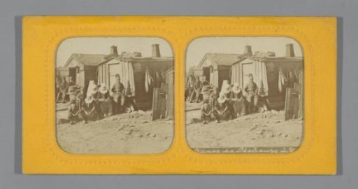 Fishermen in front of wooden huts on the beach