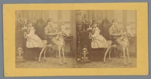 Boy on a toy horse and a girl with a doll