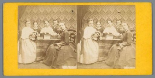 Girls around a table with possibly a stereoscope and stereoscopic photographs