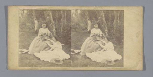 Two women on a grassy field in a forest