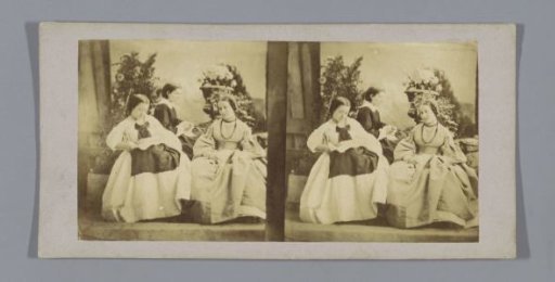 Three seated women in front of flower pots