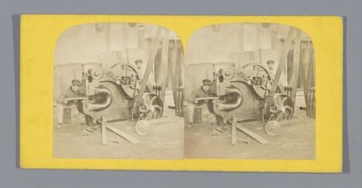 Workers at a mechanical device in a factory